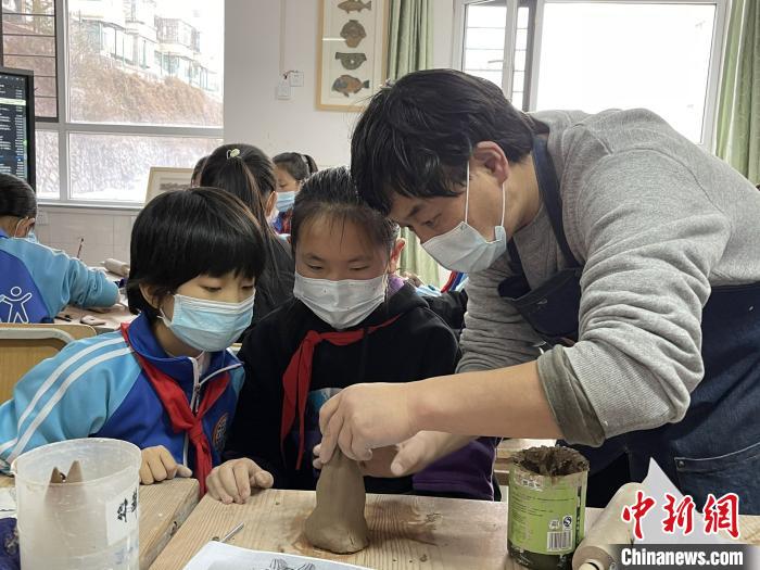 圖為西寧市勞動(dòng)路小學(xué)教師賈煜與學(xué)生一起制作陶藝。　周瑞辰子 攝