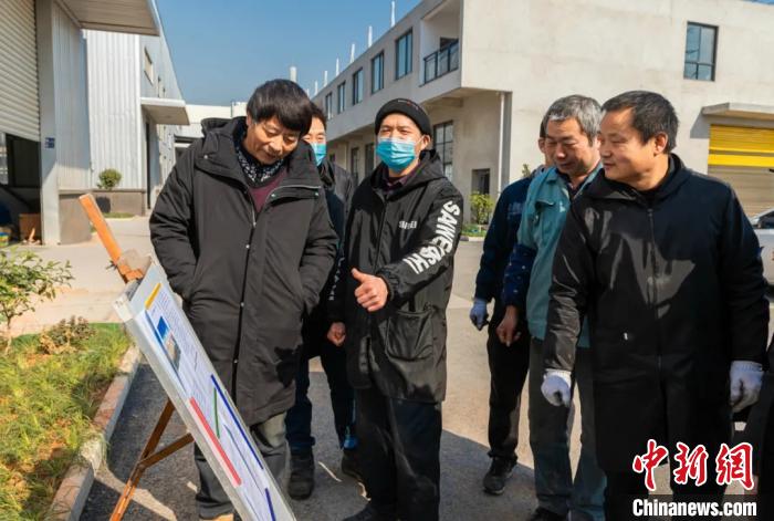 員工圍在展板前了解就地過年相關(guān)政策。婺城宣傳部供圖