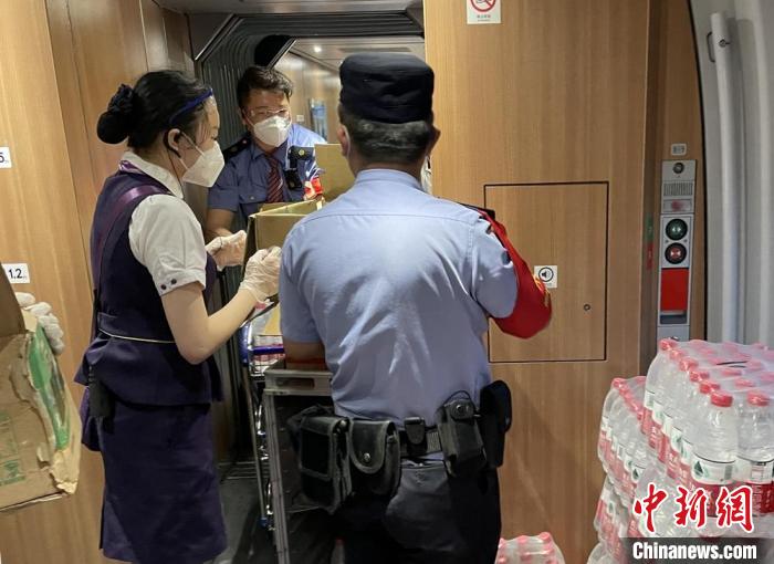 乘警與列車工作人員一起運(yùn)送礦泉水?！⌒熘蓁F路公安處供圖