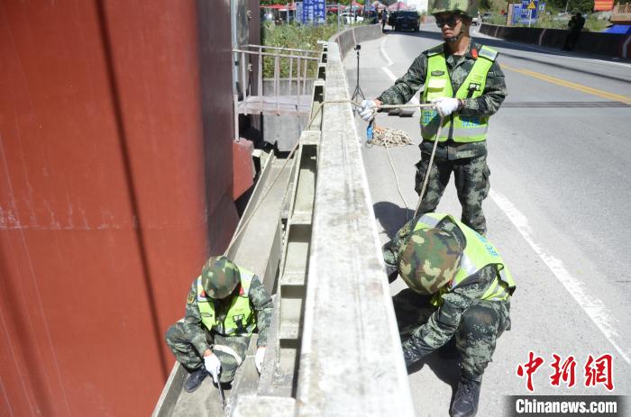 圖為武警官兵對通麥特大橋進(jìn)行養(yǎng)護(hù)?！∫笥苋?攝