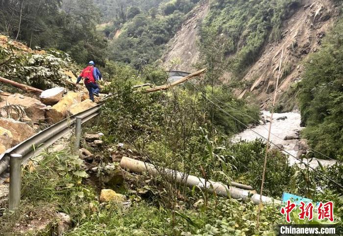 電力搶險人員快速通過危險路段，旁邊是受損的電力線路 四川電力供圖