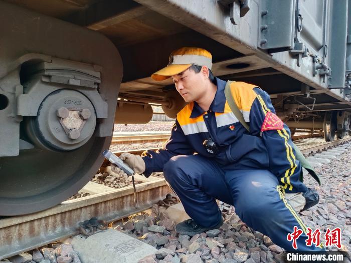 圖為張建亮在檢查車輛軸承溫度?！≈炜△?攝