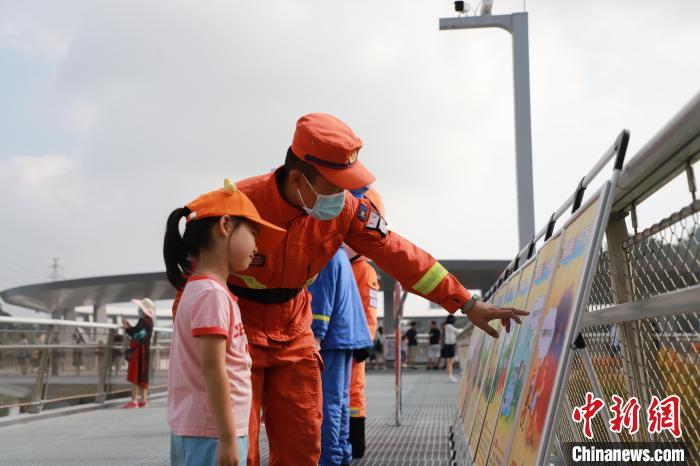 森林消防員正在防火宣傳展板前與小朋友進(jìn)行科普講解?！↑S山鴻 攝