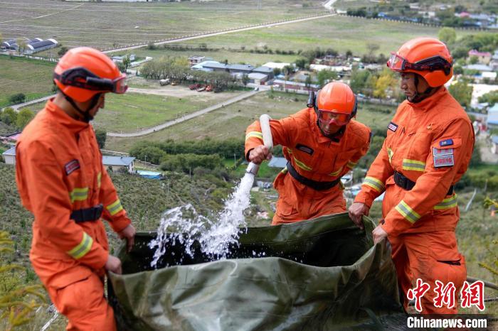 技能大練兵過程中，消防員在陡坡上向蓄水池注水。　李國(guó)燾 攝