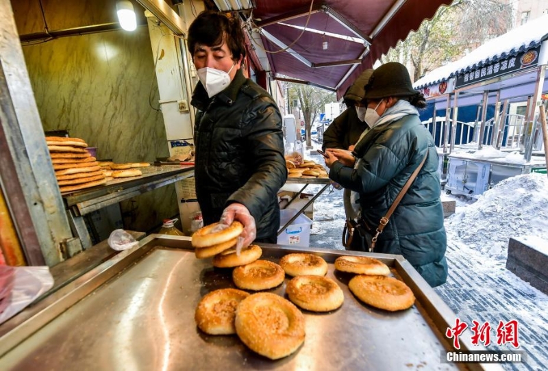 烏魯木齊市文化路，已開門營業(yè)的馕店吸引過往市民前來購買。 劉新 攝