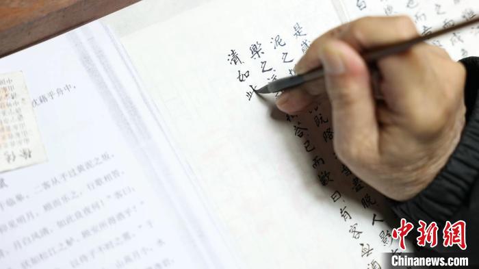 “微書寫卷”非遺傳承人謝小品正在書寫微書?！【抟翱h融媒體中心供圖