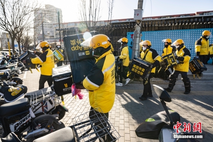 圖為外賣送餐員在北京市朝陽區(qū)的街頭開完早會后投入工作。 <a target='_blank' href='/'>中新社</a>記者 侯宇 攝