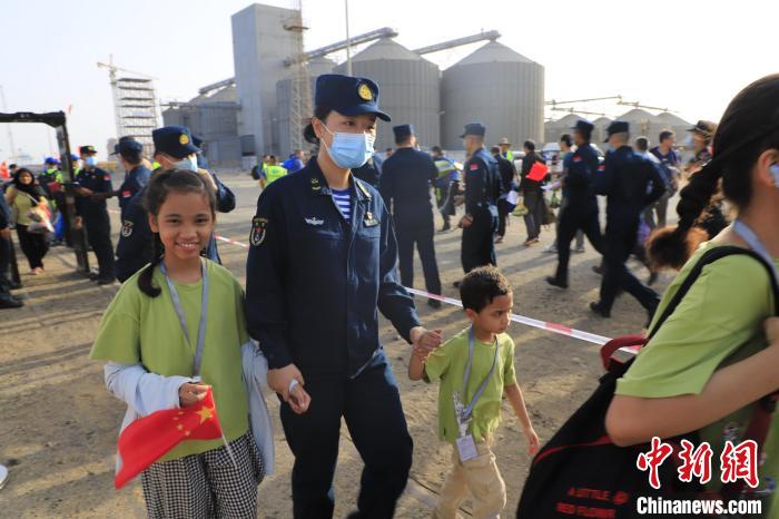 當(dāng)?shù)貢r(shí)間4月26日，海軍軍艦赴蘇丹緊急撤離我在蘇丹人員。圖為海軍官兵手牽著兒童通過(guò)安檢?！《〖遗d 攝