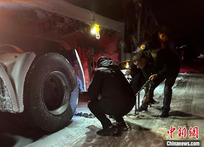 圖為民警幫助受困車(chē)輛安裝防滑鏈?！」逯菸麄鞑抗﹫D