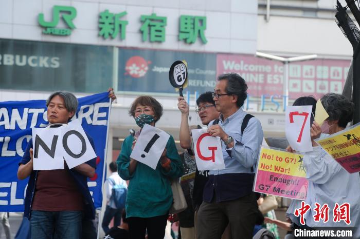 5月21日，日本民眾手舉標語，在東京新宿車站附近舉行集會，強烈抗議G7廣島峰會。　蔣文月 攝