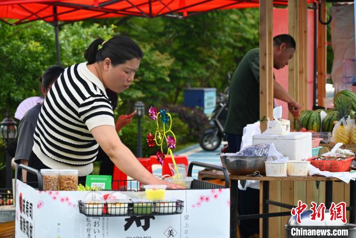 上金貝村村民擺攤售賣畬族美食?！∮嗌强?攝