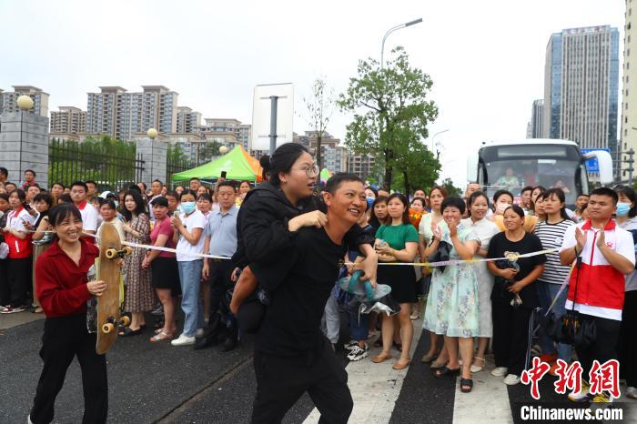 圖為蔣張子怡的父親背著她往外走，母親拿著女兒的滑板跟在后面?！⒄祭?攝