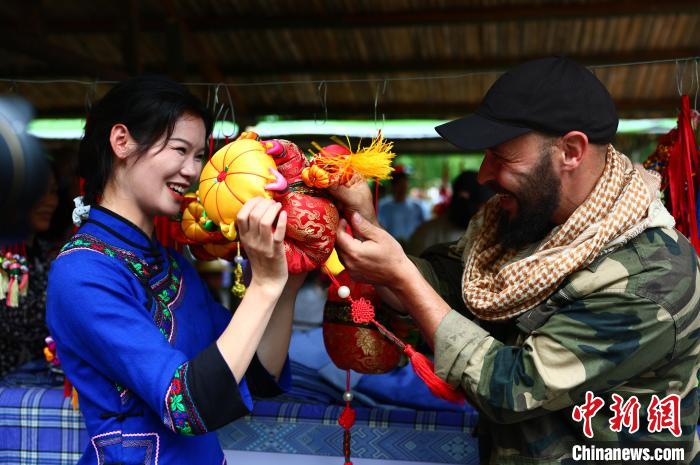 圖為一名來(lái)自德國(guó)的游客與身著民族服裝的壯族姑娘互動(dòng)?！畋厥?攝