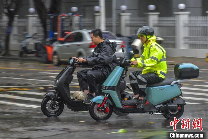 圖為海口市民冒雨出行?！●樤骑w 攝