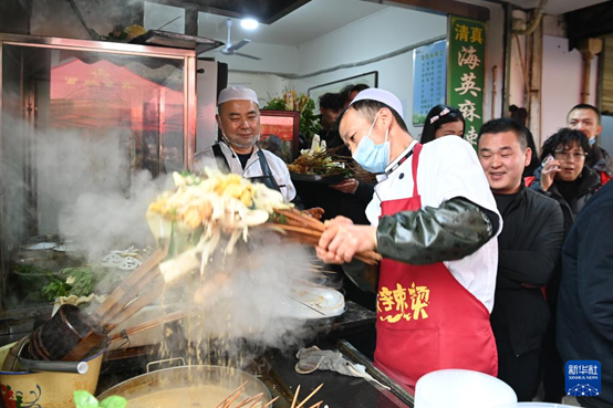 近日，天水市秦州區(qū)的天水名優(yōu)小吃城一麻辣燙店，商家為游客加工麻辣燙。 新華社記者 范培珅攝