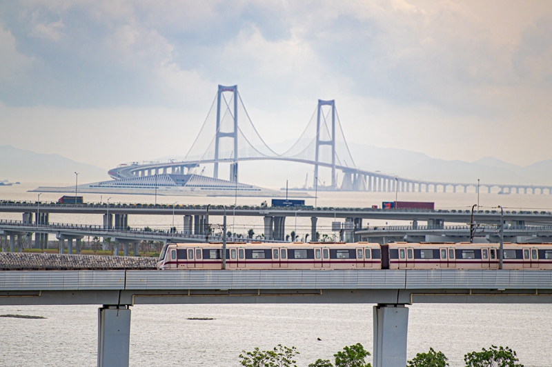 2024年6月19日，深圳地鐵11號線列車和廣深沿江高速上的車輛經(jīng)過深中通道的深中大橋和西人工島。（圖源：新華社）